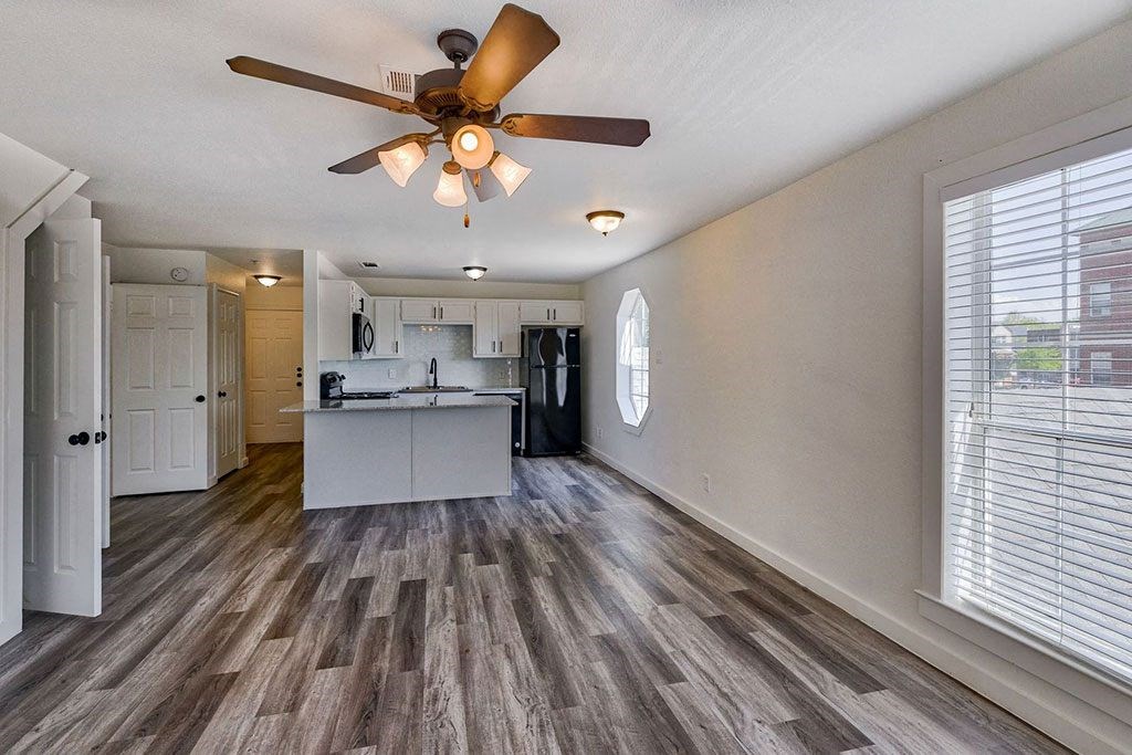 a kitchen and living room with a ceiling fan