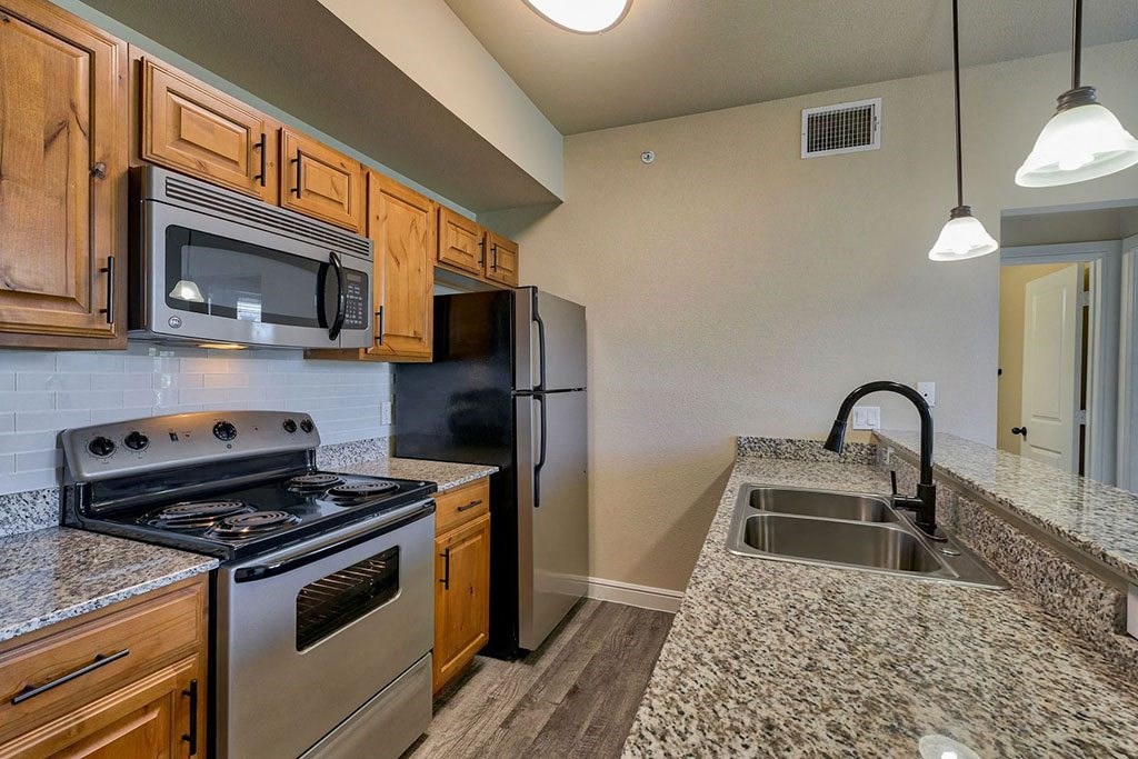 a kitchen with granite countertops and stainless steel appliances