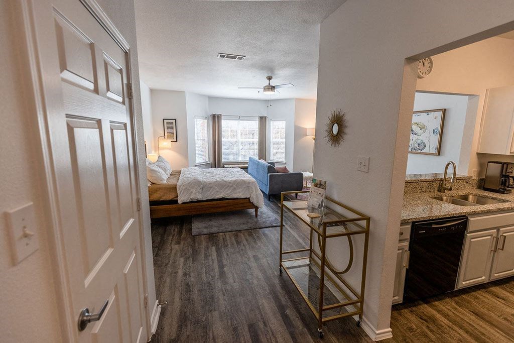 a bedroom with a bed sitting next to a kitchen