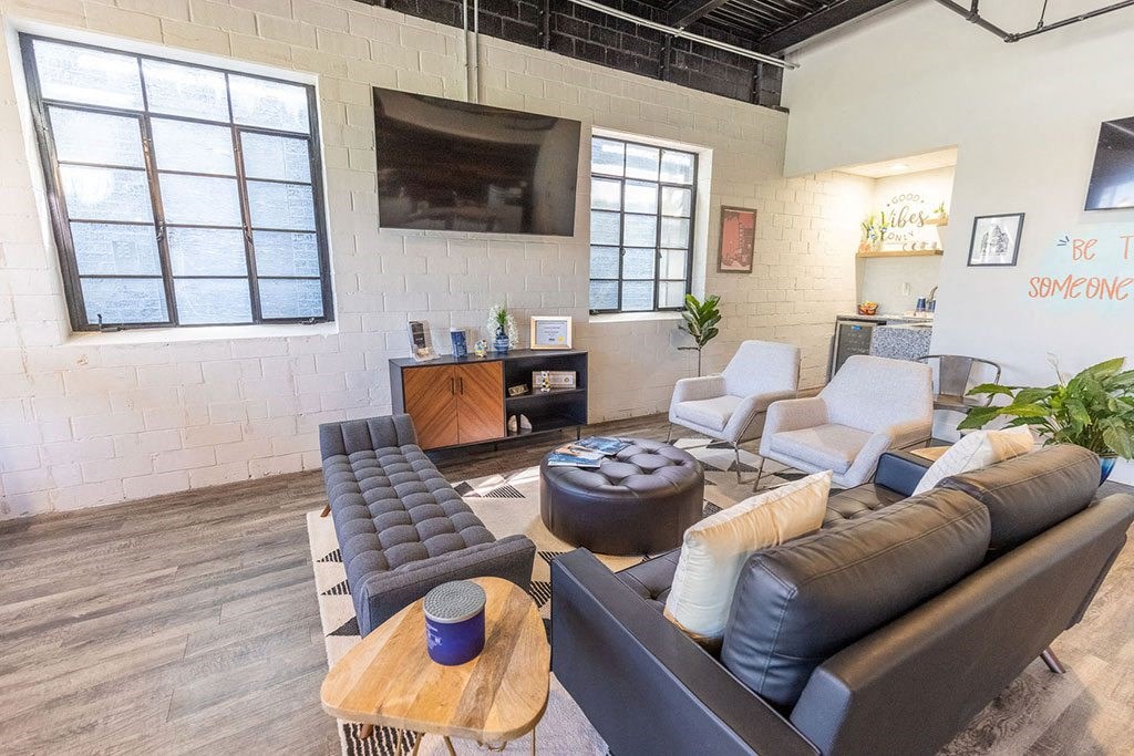 a living room with couches and chairs in front of a flat screen tv