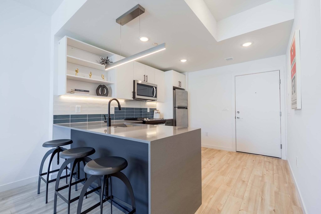 A kitchen with a bar stool and a counter.