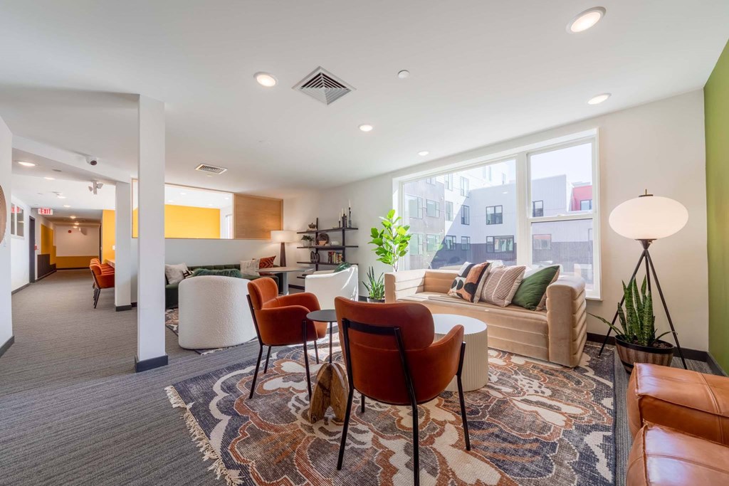 A living room with a grey carpet and a brown leather chair.