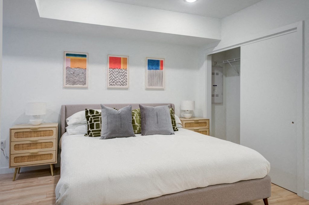 a bedroom with a bed and paintings on the wall