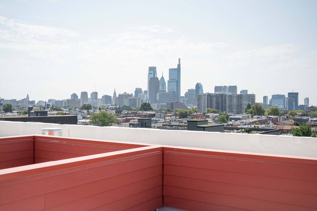 the view of the city from the rooftop terrace of a building with a bench