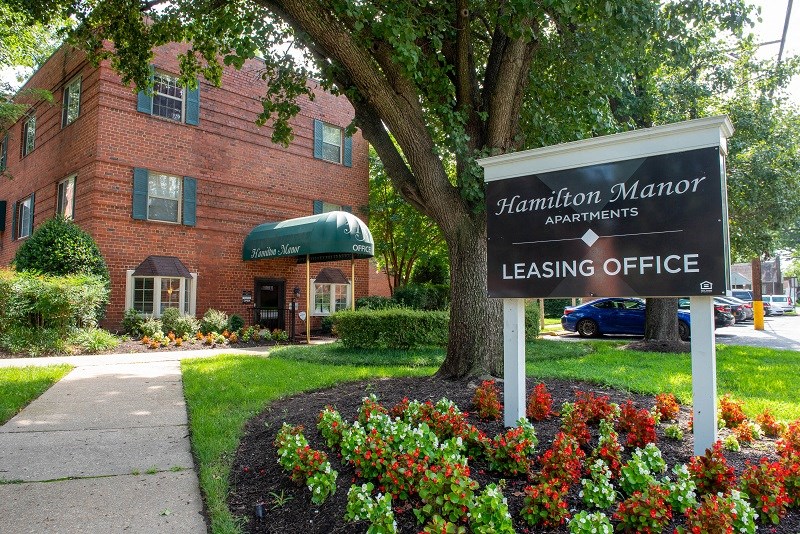 a sign for the apartments leasing office in front of a building