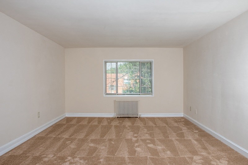an empty room with carpet and a window