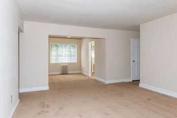 the living room and dining room of an empty house with white walls and flooring