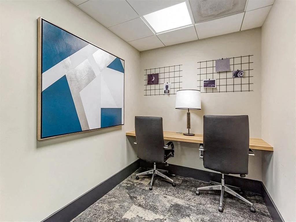 a room with a desk and two chairs