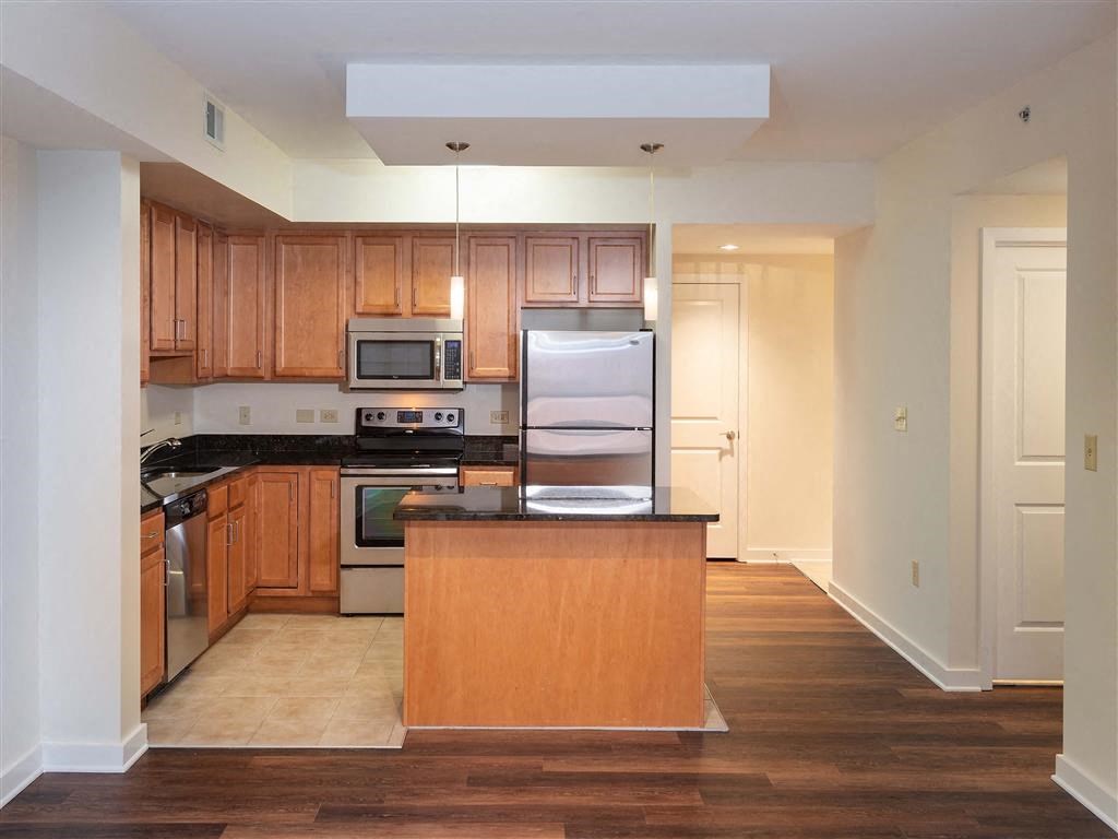 a large kitchen with wooden cabinets and a refrigerator