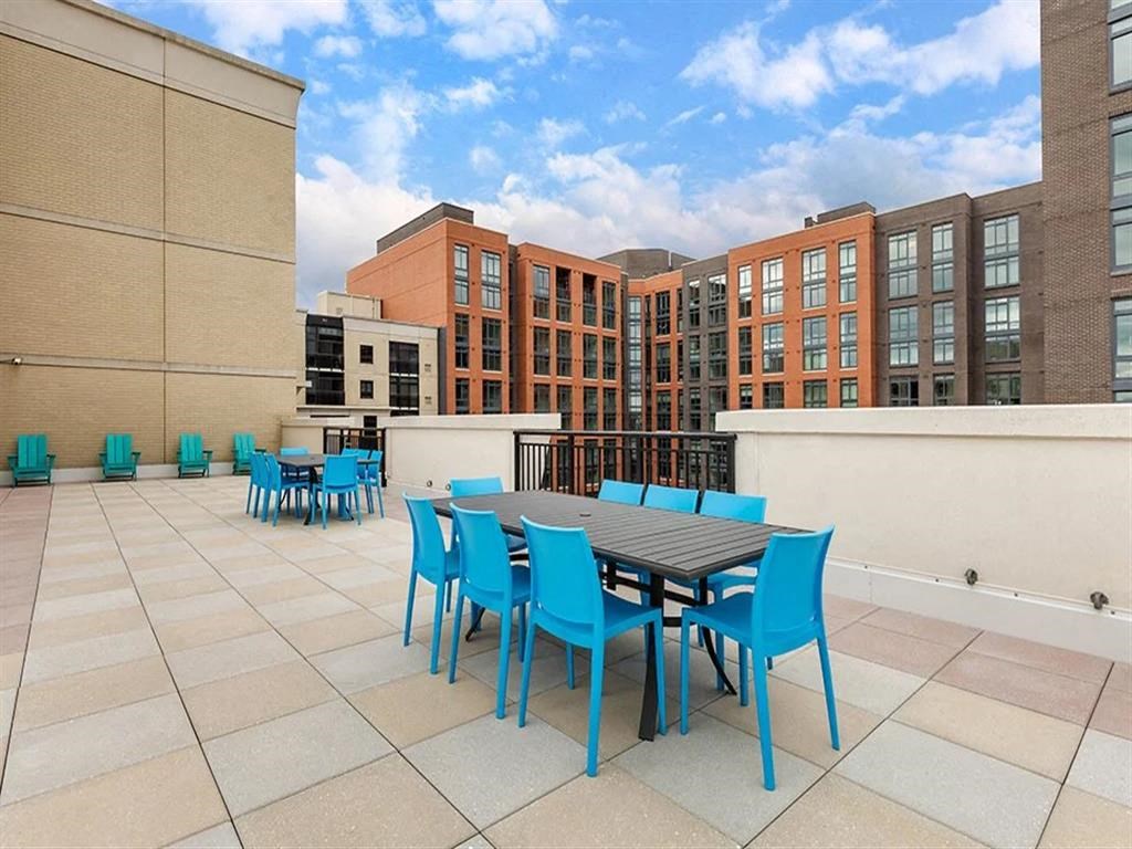 a patio with a table and chairs on top of a building