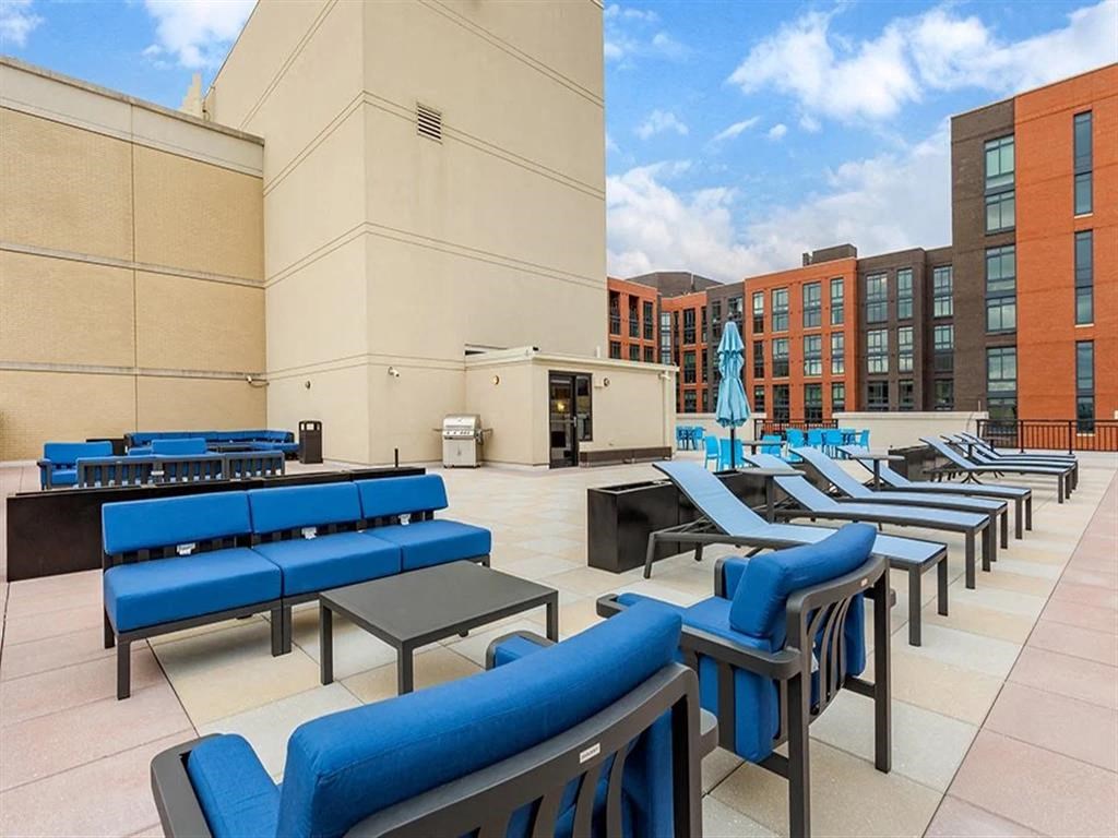 a lounge area with blue chairs and tables at a building