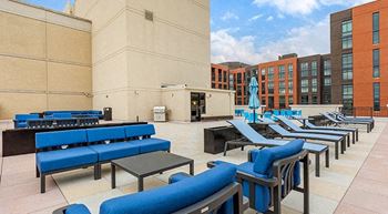an outdoor lounge area with blue chairs and tables