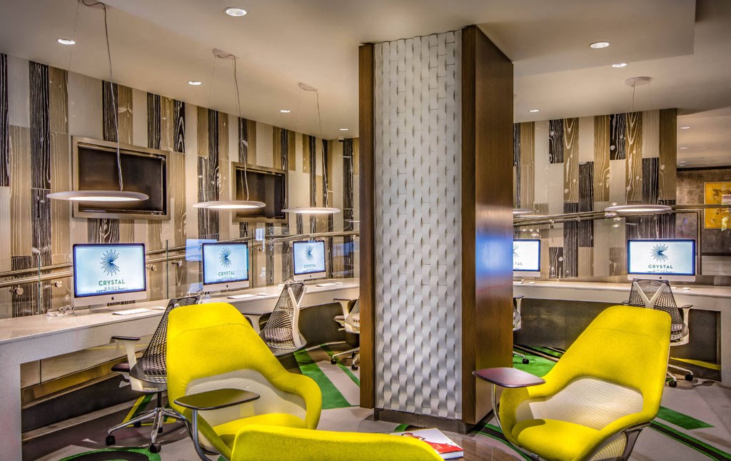 a lobby with yellow chairs and computer monitors