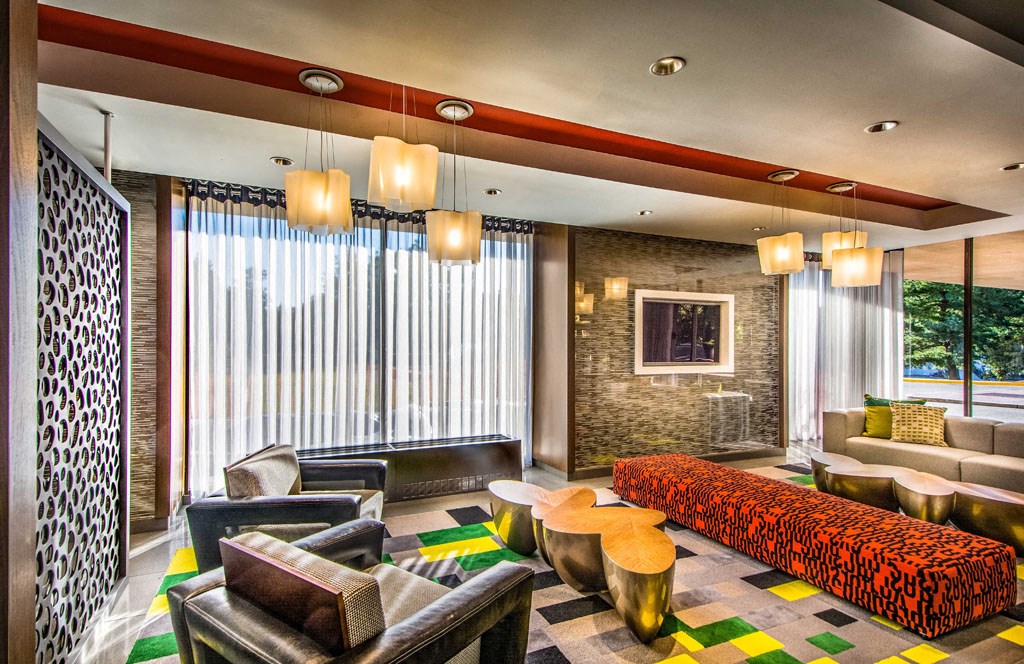 a hotel room with a bed and couches and chairs