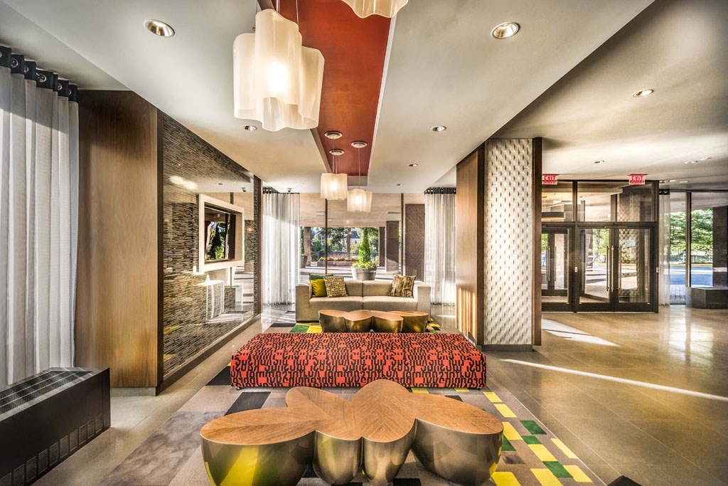 the lobby of a hotel with a large couch and tables
