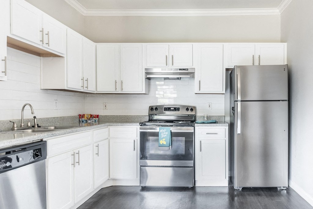Affordable Houston Texas Apartments – Westchase Forest – Photo of upgraded kitchen with white cabinets and stainless steel appliances