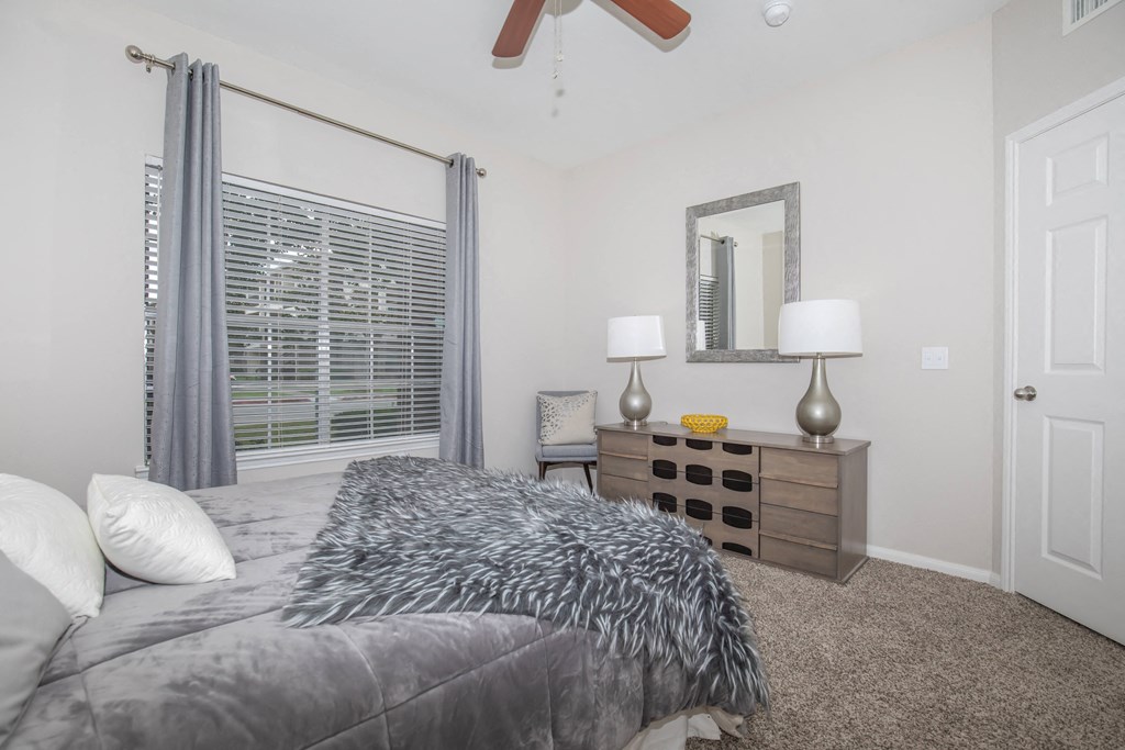 Pet-Friendly Apartments in Houston, TX – Westchase Forest – Photo of a bedroom with a large bed and a ceiling fan