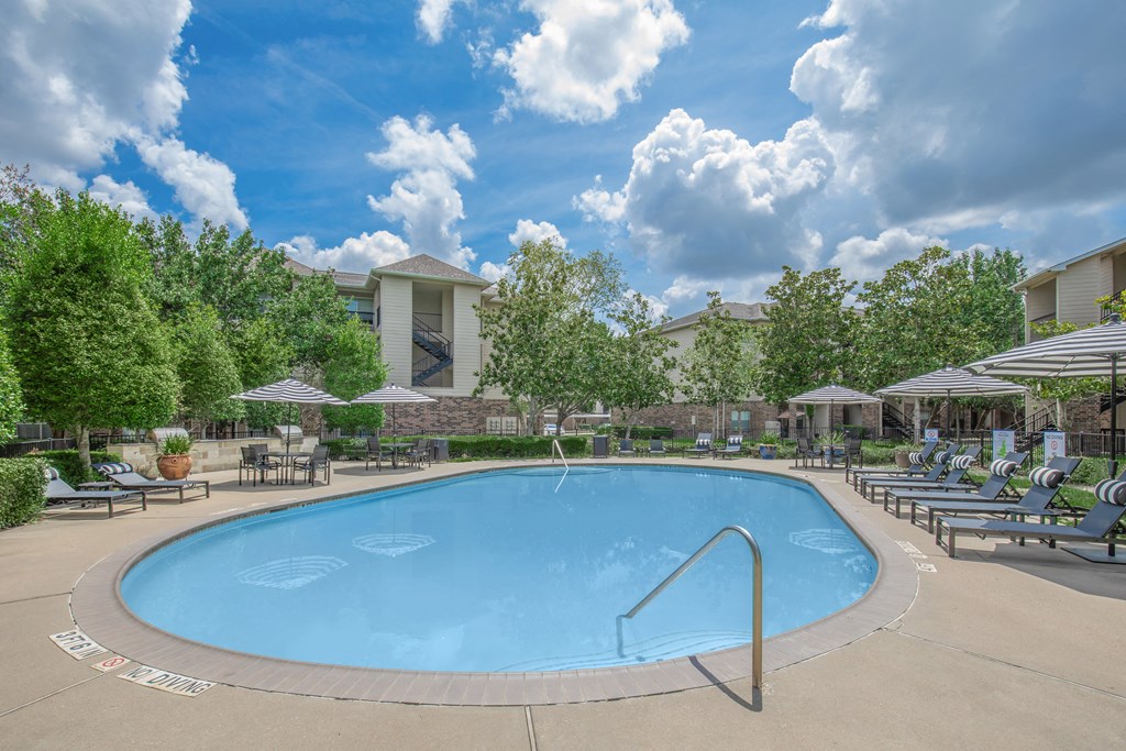 Apartments In Houston Texas for Rent – Westchase Forest - Photo of a swimming pool with chairs and umbrellas