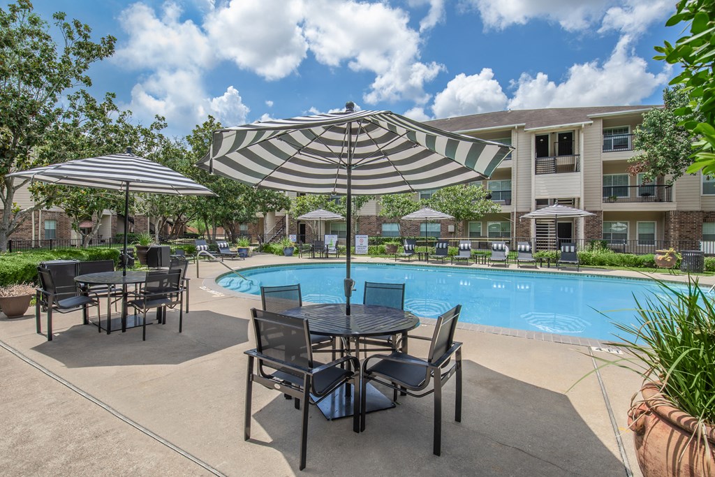 Pet-Friendly Apartments in Houston, TX – Westchase Forest – Photo of our apartments offer a swimming pool with tables and umbrellas