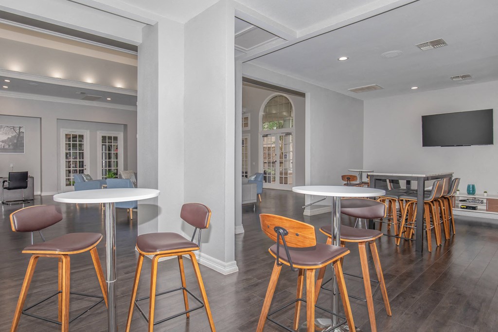 Pet-Friendly Apartments in Houston, TX – Westchase Forest – Photo of a community room with tables and chairs and a tv