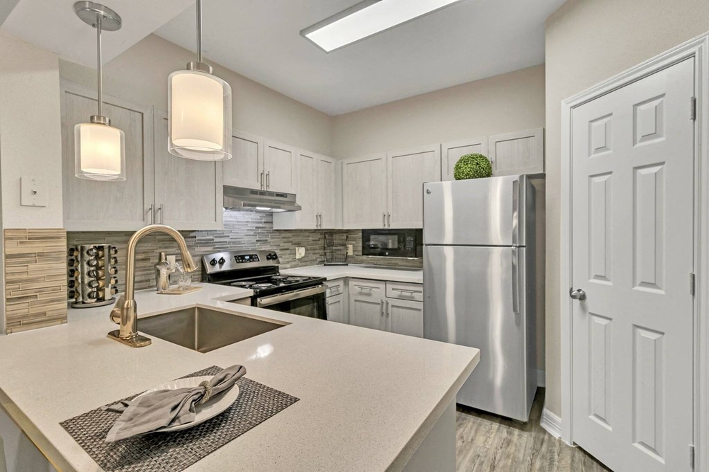 Affordable Houston Texas Apartments – Gramercy Park – Photo of an open kitchen with white cabinets and stainless steel appliances