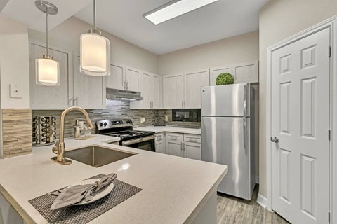 an open kitchen with white cabinets and stainless steel appliances