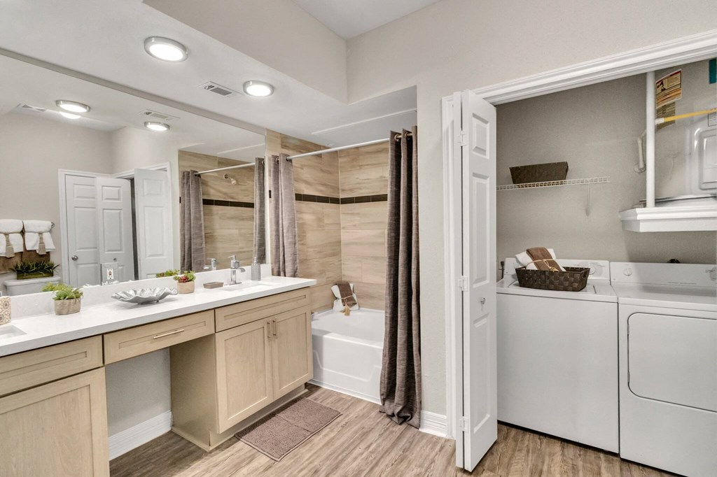 Apartments near Alief Texas for Rent – Gramercy Park - Photo of a laundry room with a washer and dryer and a shower and a sink