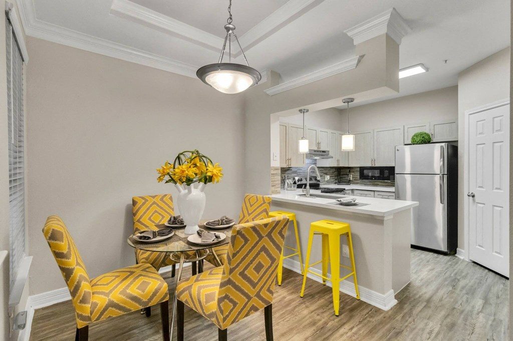 Apartments near Alief Texas for Rent – Gramercy Park - Photo of a dining room and kitchen with yellow chairs and a table