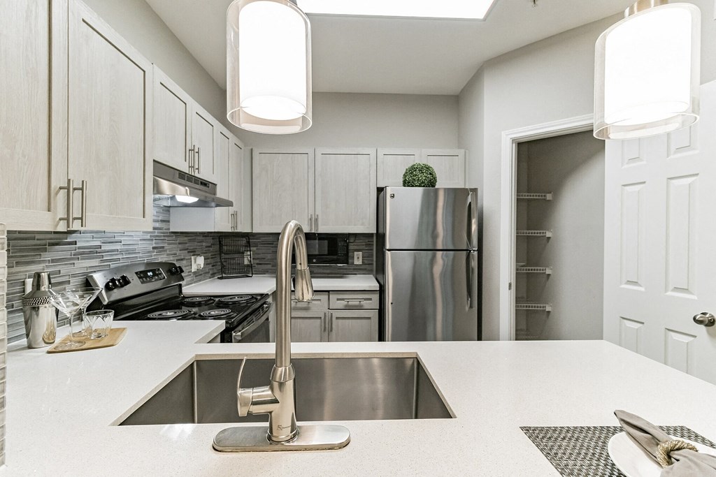 Pet-Friendly Apartments in Houston, TX – Gramercy Park – Photo of an open kitchen with stainless steel appliances and white cabinets