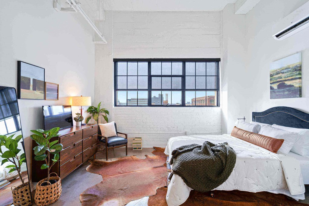 a bedroom with a bed and a large window