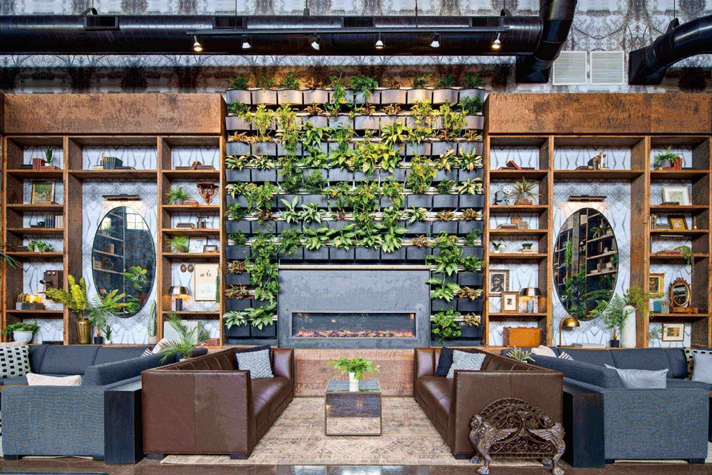a living room with a fireplace and plants on the wall