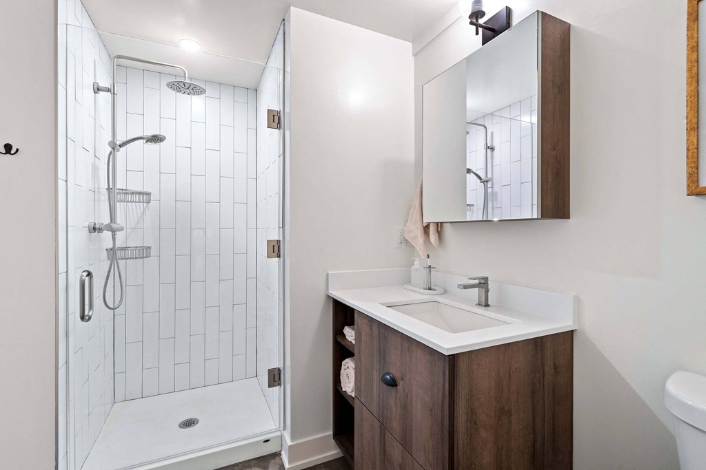 a bathroom with a shower and a sink and a mirror