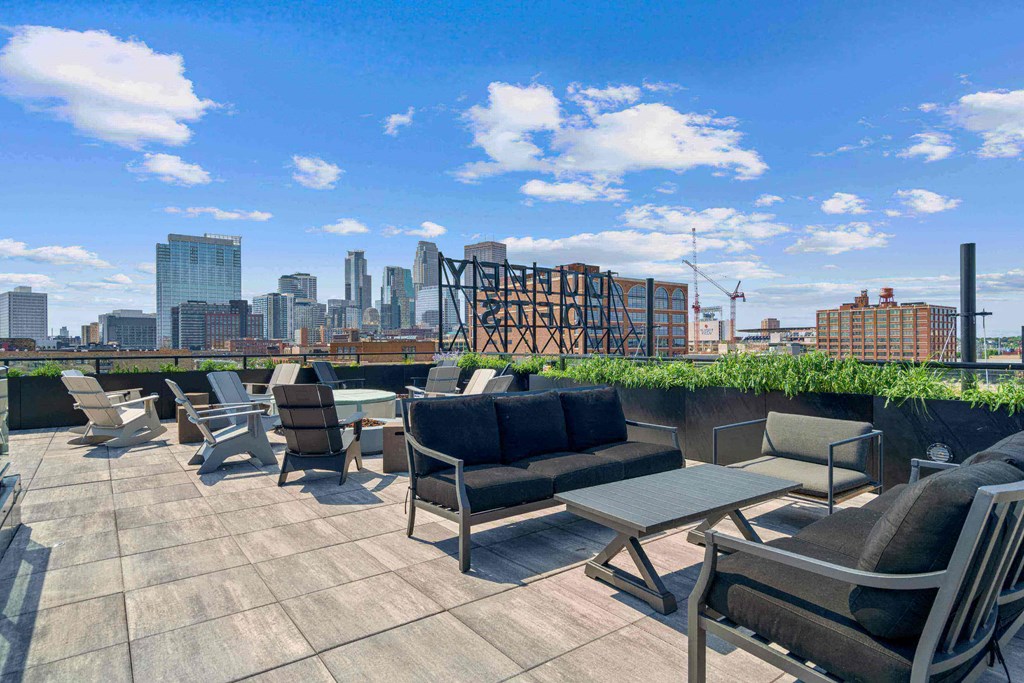 a roof top patio with chairs and tables and a view of the city