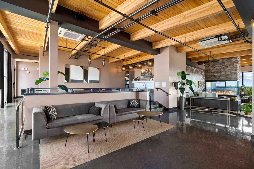 a lobby with couches and tables and a kitchen