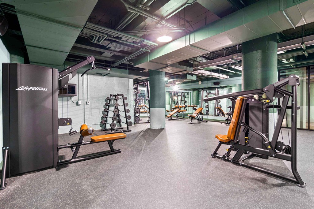 a gym with weights and exercise equipment in a building