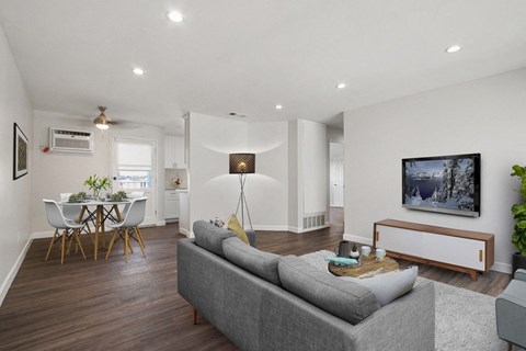 A living room with a grey couch and a white table.