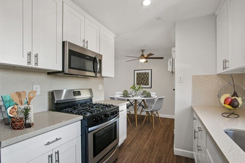 A kitchen with white cabinets and a black stove top.