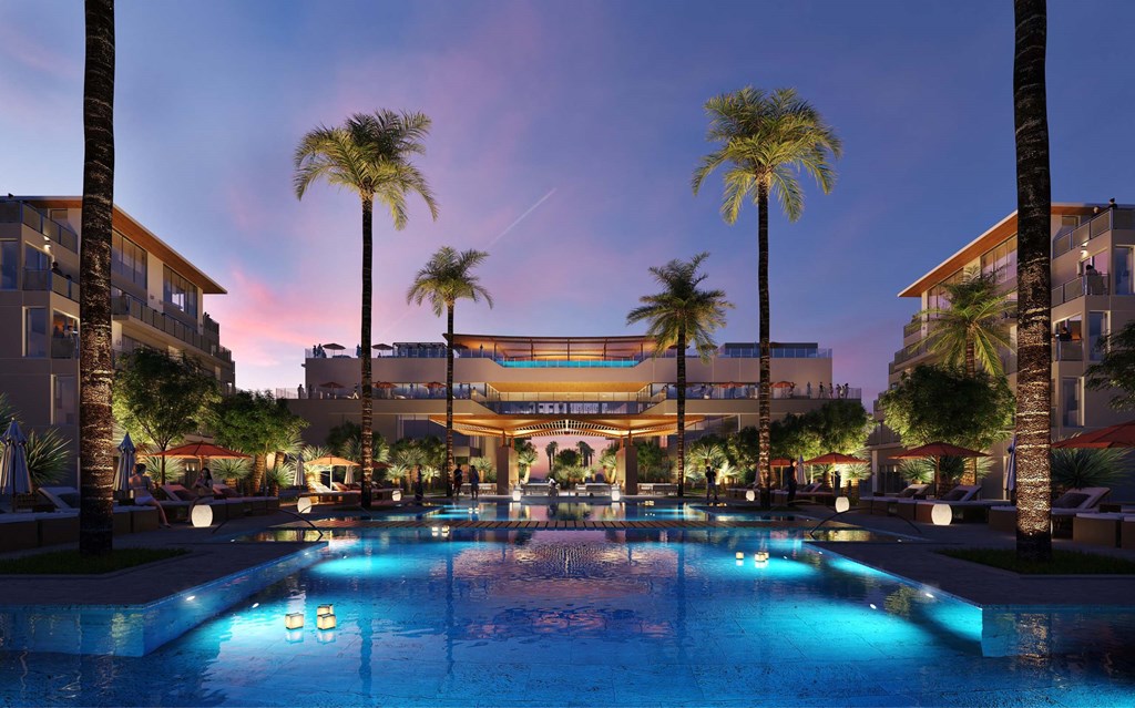A pool surrounded by palm trees and lit up with blue lights.