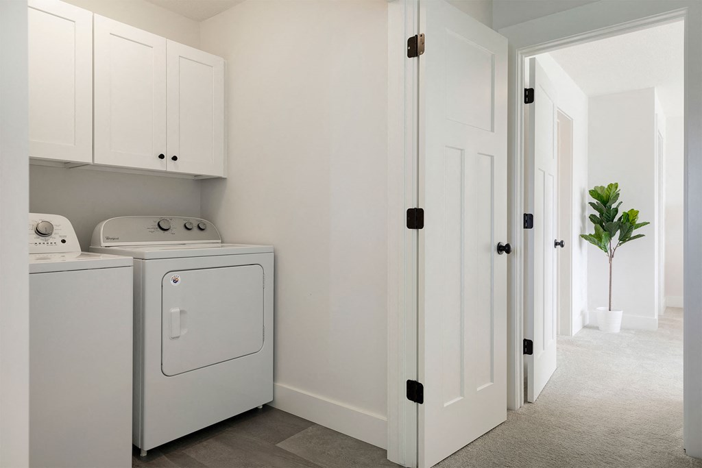 A white laundry room with a washer and dryer.