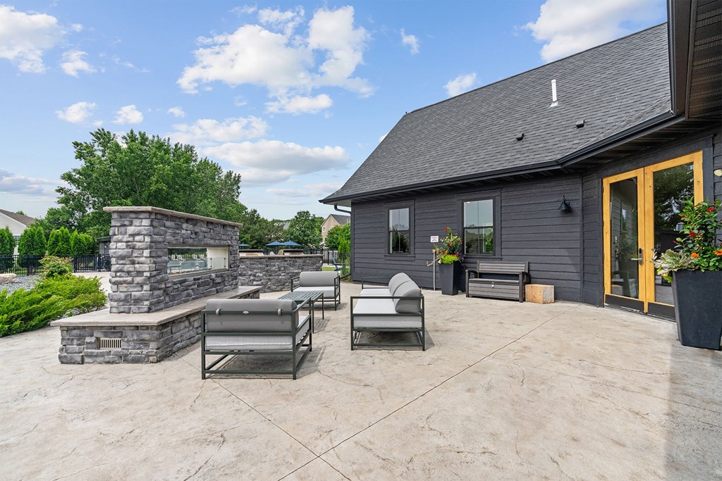 A patio with a stone fireplace and a couch.