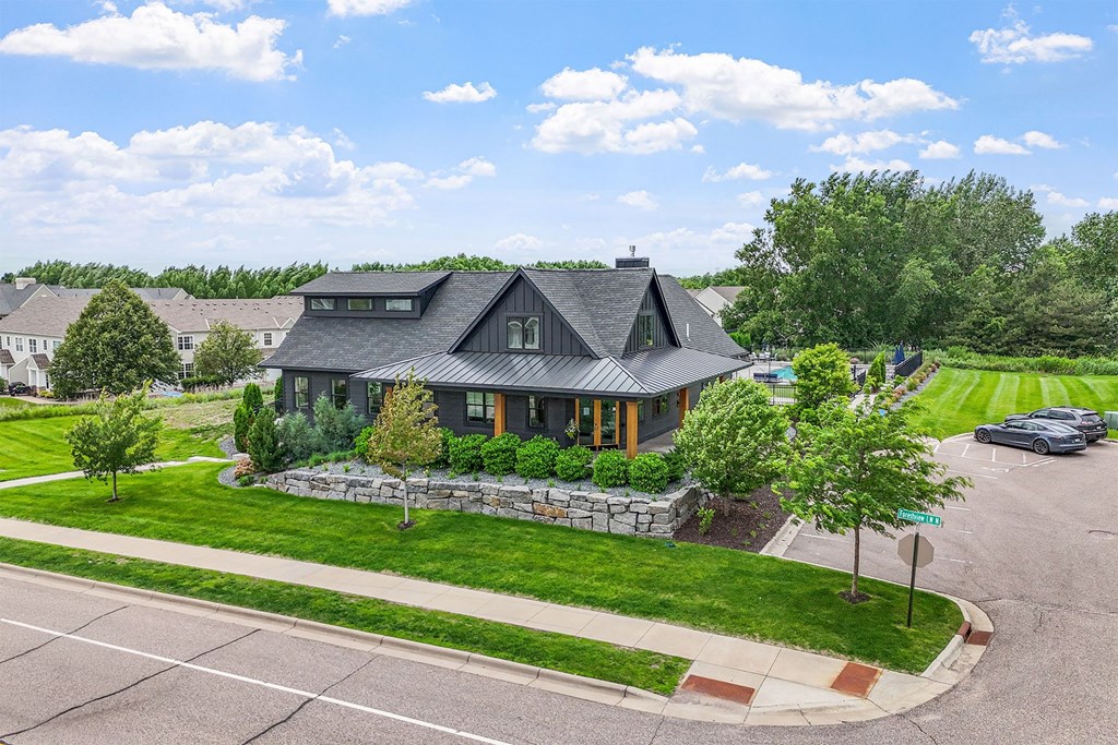 A house with a green lawn and a car parked in front.