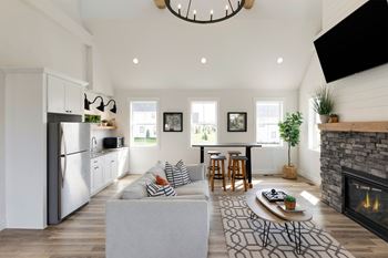 A modern kitchen with a refrigerator, a dining table with chairs, and a fireplace with a plant on top.