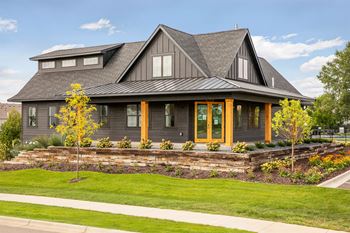 A modern house with a grey roof and wooden windows.