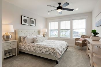 A bedroom with a large bed and a ceiling fan.