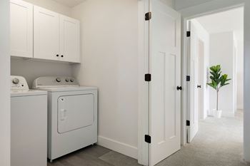 A white laundry room with a washer and dryer.