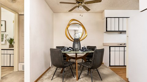 Dining area inside a classic apartment at Willowstone Apartments featuring ceiling fan and open access to kitchen
