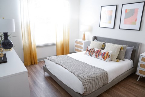 A bedroom with a large bed and two nightstands.