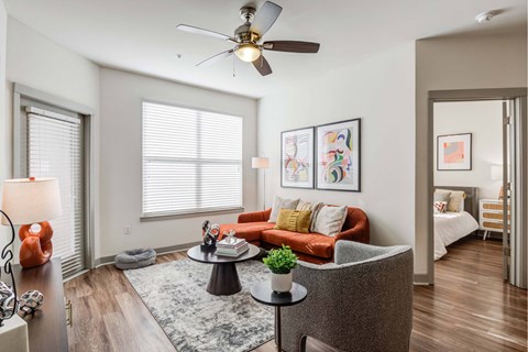 A living room with a red couch and a ceiling fan.