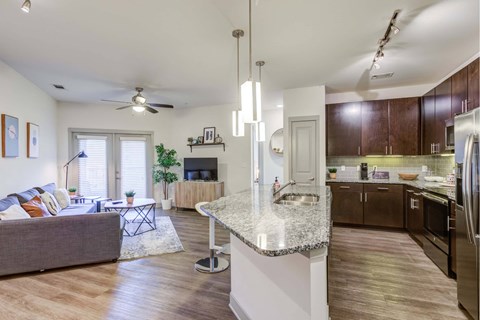 A modern kitchen with dark wood cabinets and stainless steel appliances.