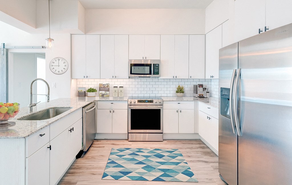 a kitchen with white cabinets and stainless steel appliances